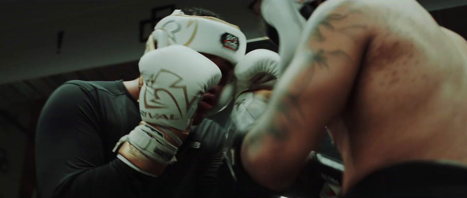 a man with a tattoo on his arm wearing boxing gloves