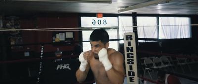 a young man standing in a boxing ring