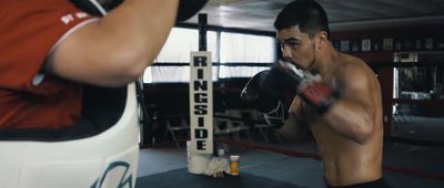 a man standing next to a punching bag