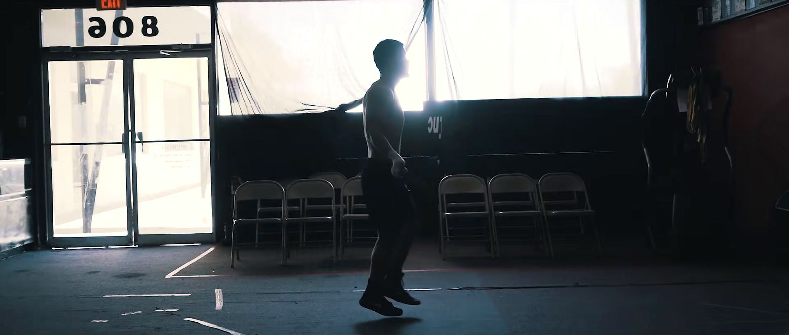 a person standing in a dark room with chairs