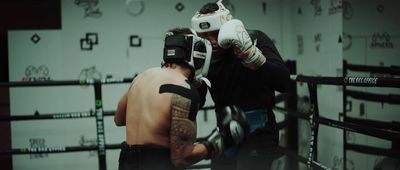 a man with a tattoo on his arm wearing boxing gloves