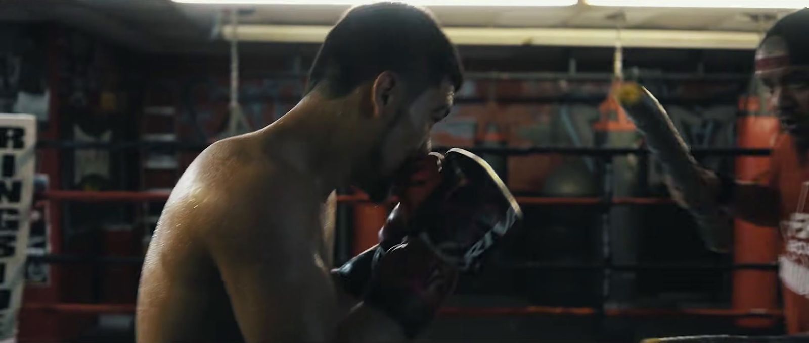 a man standing next to another man in a boxing ring