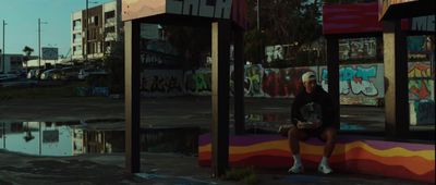 a person sitting on a bench in front of a puddle