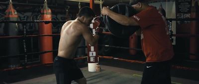 a couple of men standing next to each other in a boxing ring