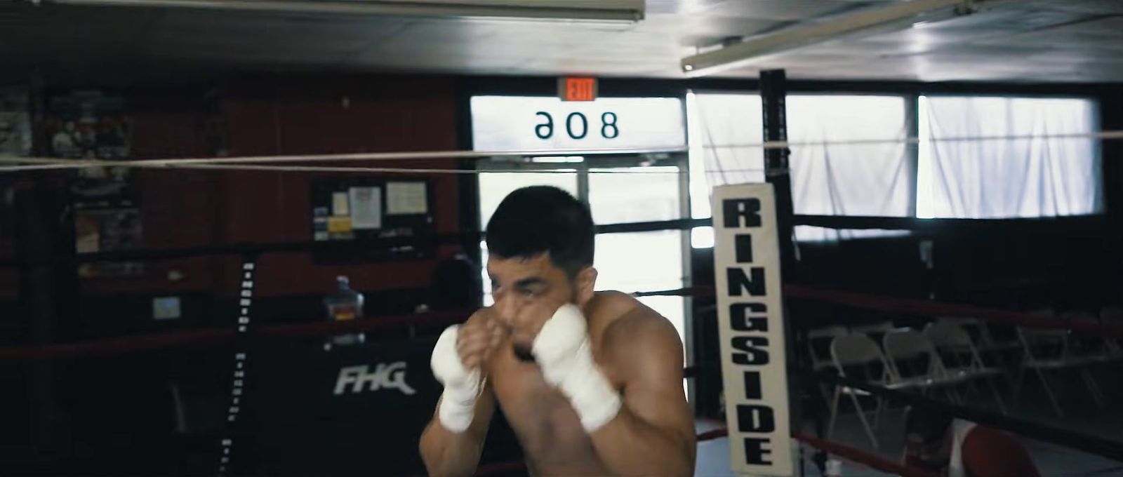 a man standing in a boxing ring holding a white glove