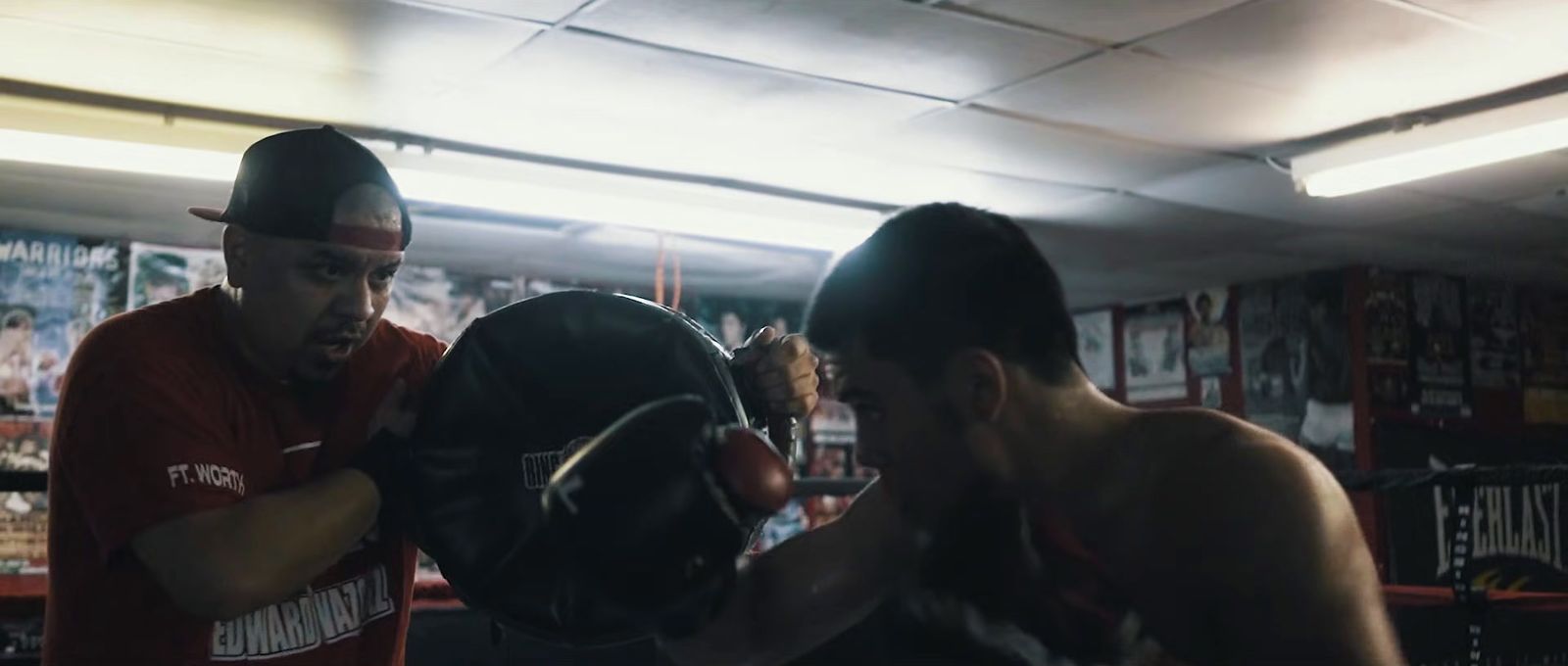 a couple of men standing next to each other in a boxing ring