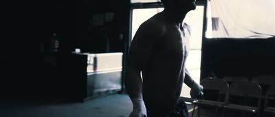 a man standing in a dark room next to a window