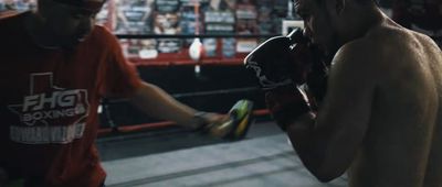 a man standing next to another man in a boxing ring