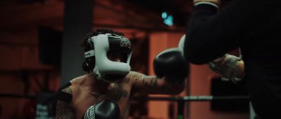 a man with a tattoo on his arm wearing boxing gloves