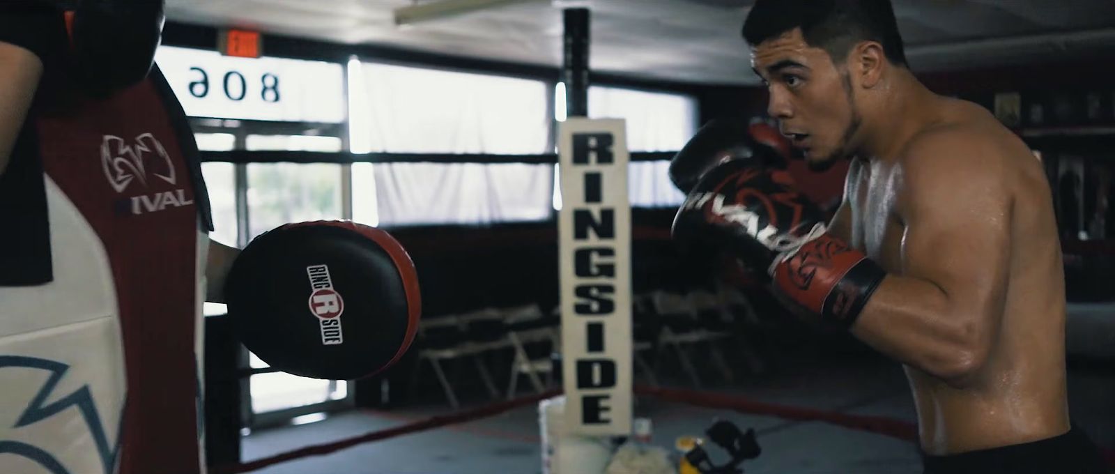 a man standing next to a punching bag