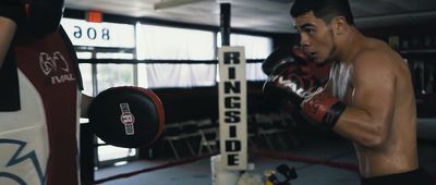 a man standing next to a punching bag