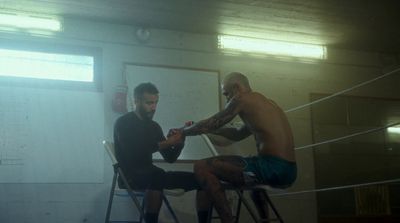 two men sitting on stools in a room