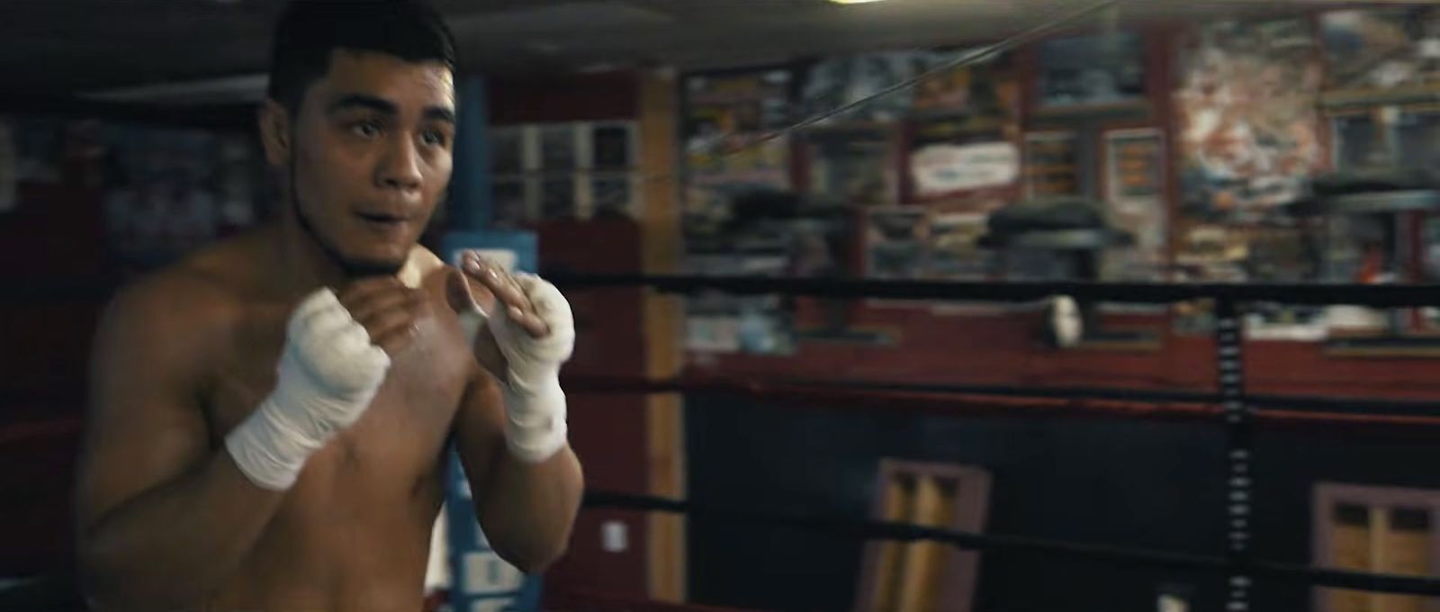 a young man wearing boxing gloves in a boxing ring