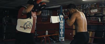 a man standing next to another man in a boxing ring