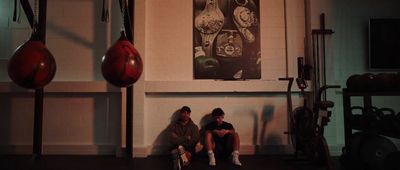 two people sitting on a bench in a gym