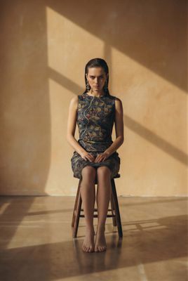 a woman sitting on top of a wooden chair