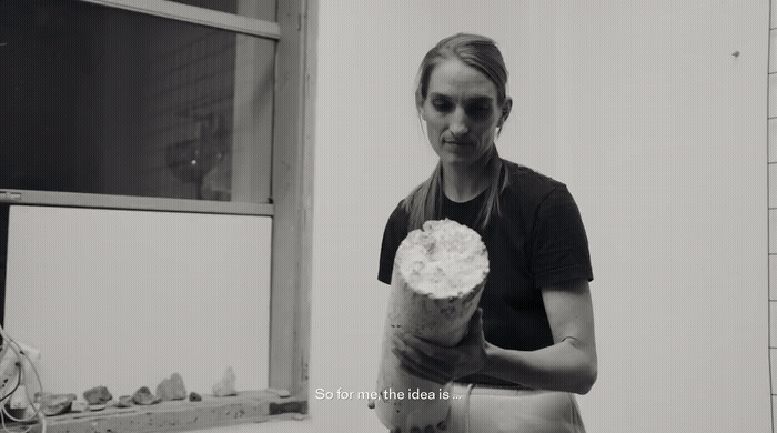 a black and white photo of a woman holding a pastry