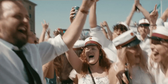 a group of people wearing hats and holding their hands in the air