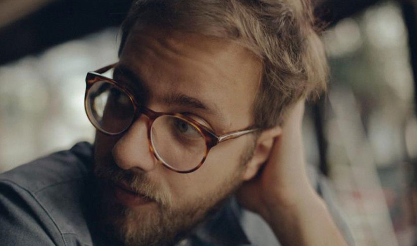 a man with a beard and glasses looking at something