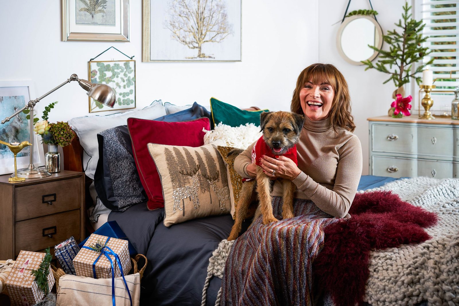 a woman sitting on a bed holding a dog