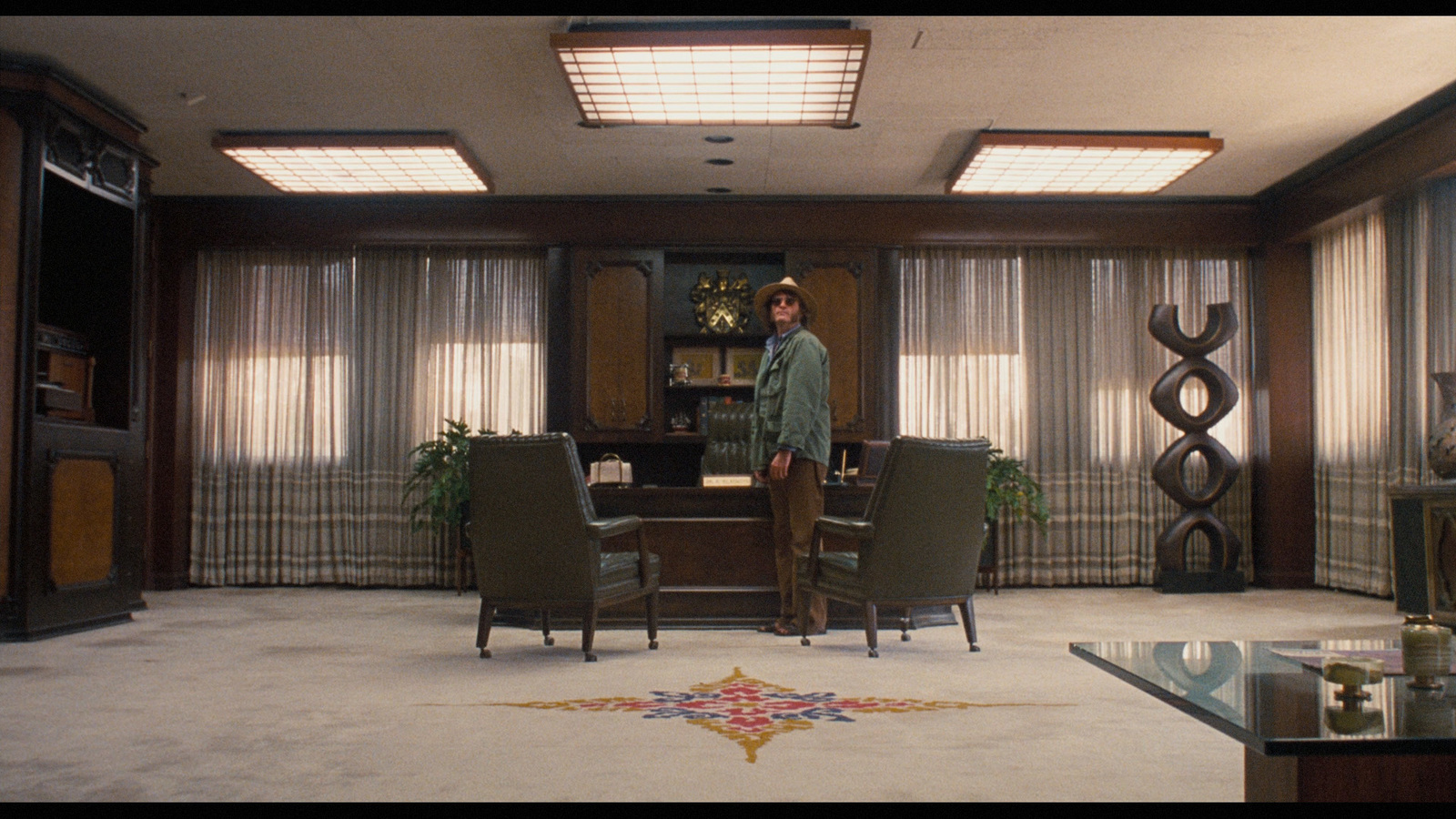 a man standing in a living room next to a table