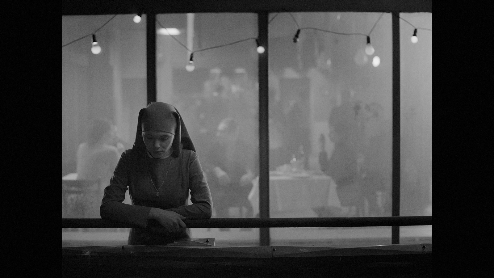 a woman sitting at a table in front of a window