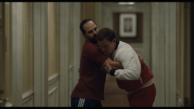 a couple of men standing next to each other in a hallway