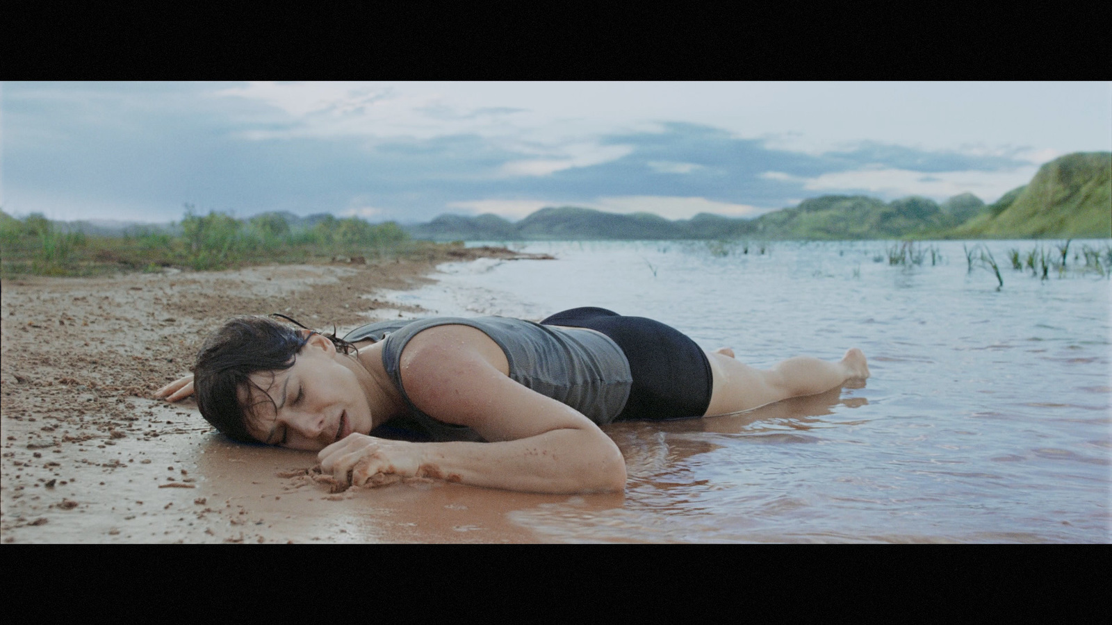 a woman laying on the beach in the water