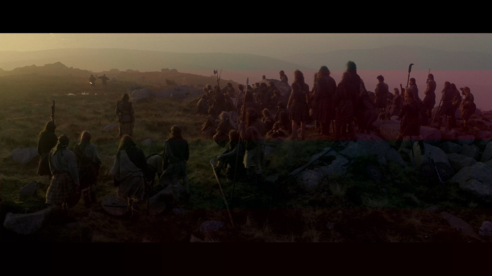 a group of people standing on top of a lush green hillside