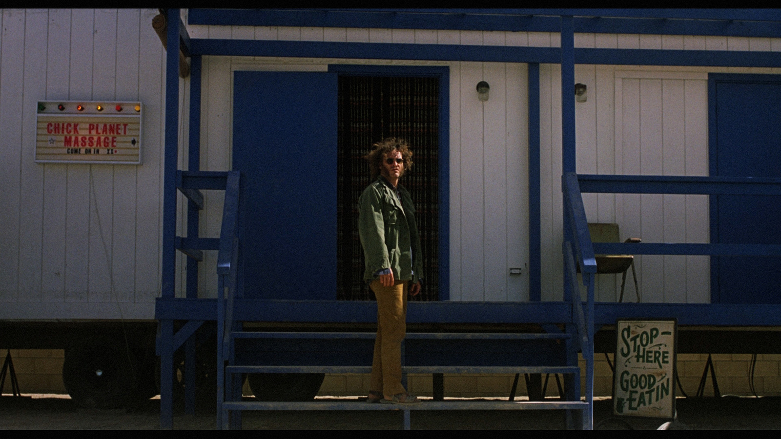 a man standing outside of a blue and white building