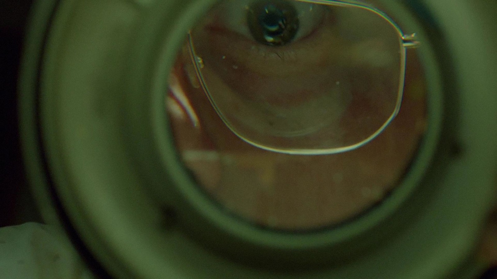 a close up of a glass with a reflection of a person's eye