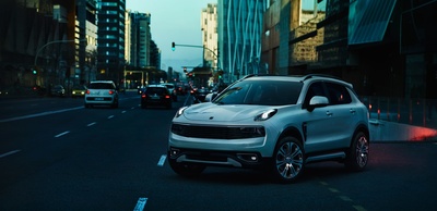 a white suv driving down a city street