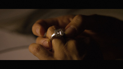 a person holding a diamond ring in their hand