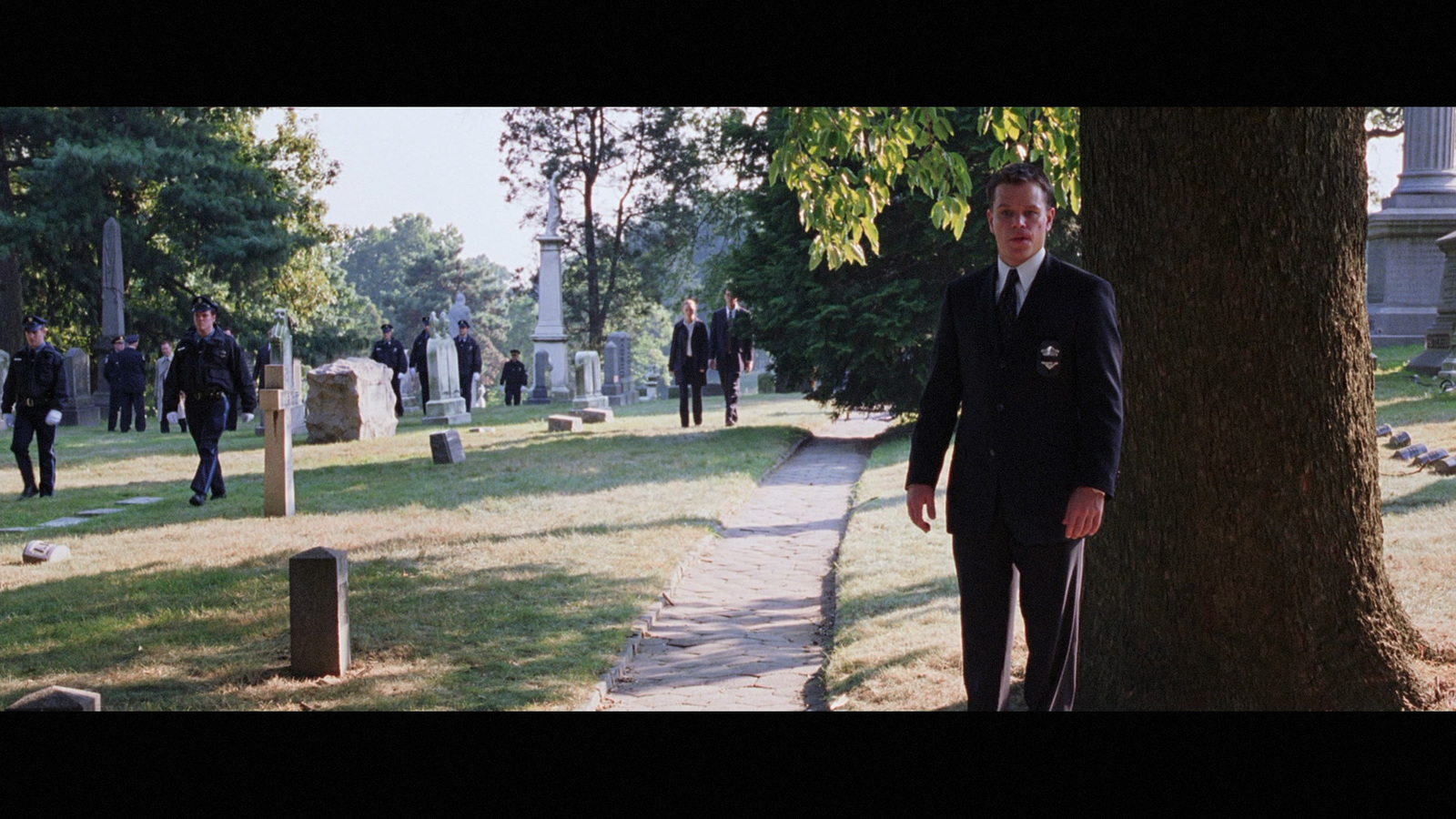 a man in a suit standing next to a tree