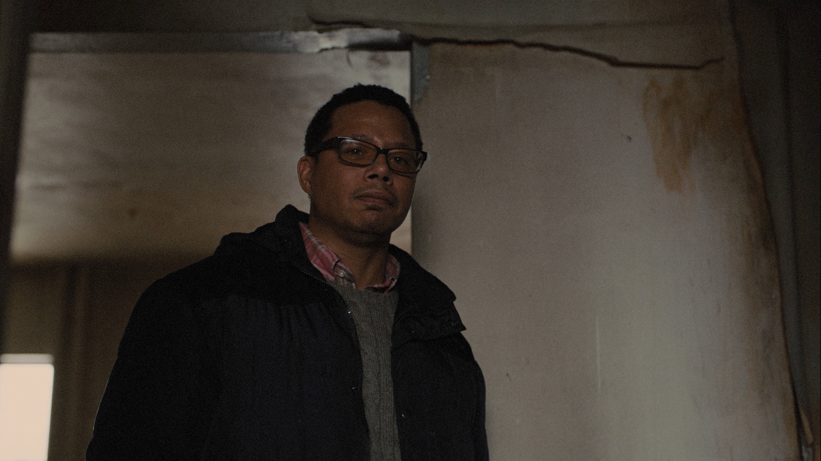 a man wearing glasses standing in a room