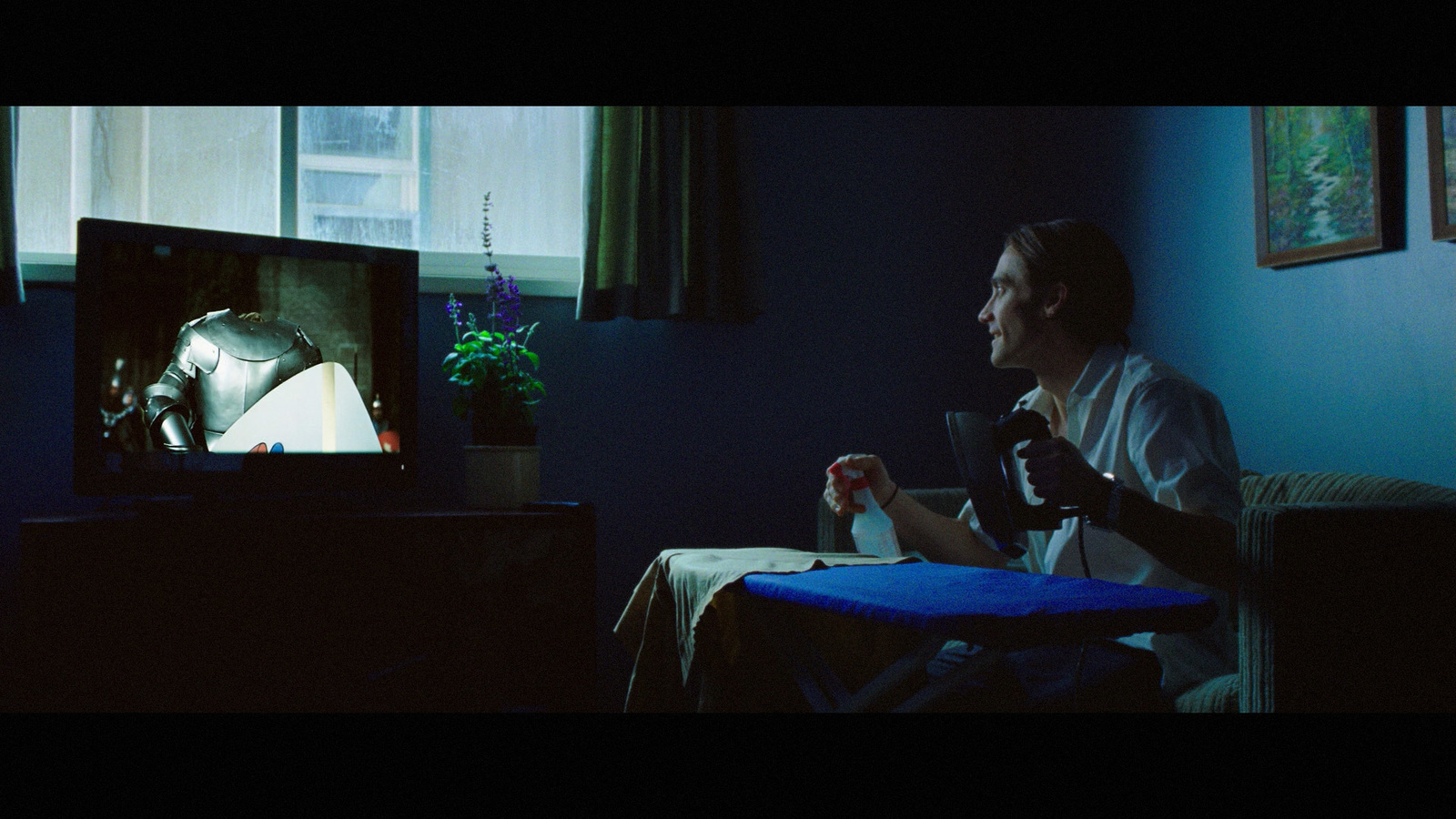 a man sitting in a chair in front of a tv