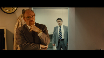 a man in a suit and tie standing in front of a mirror