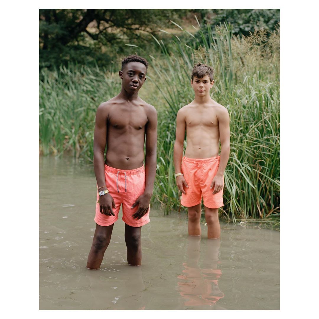 two young boys standing in a body of water