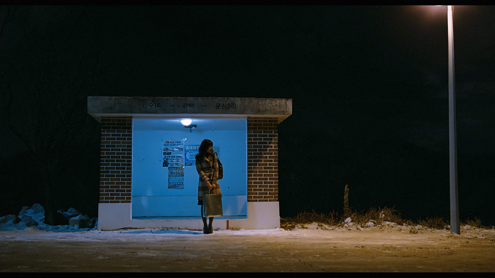 a woman standing in front of a building at night