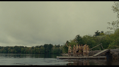 a group of people standing on a dock next to a body of water