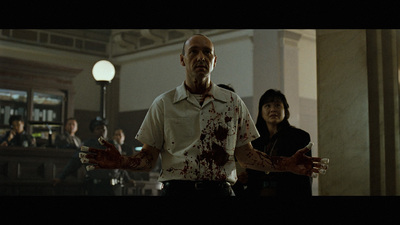 a man standing next to a woman with blood on his hands