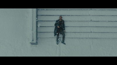 a person standing in the snow next to a fence