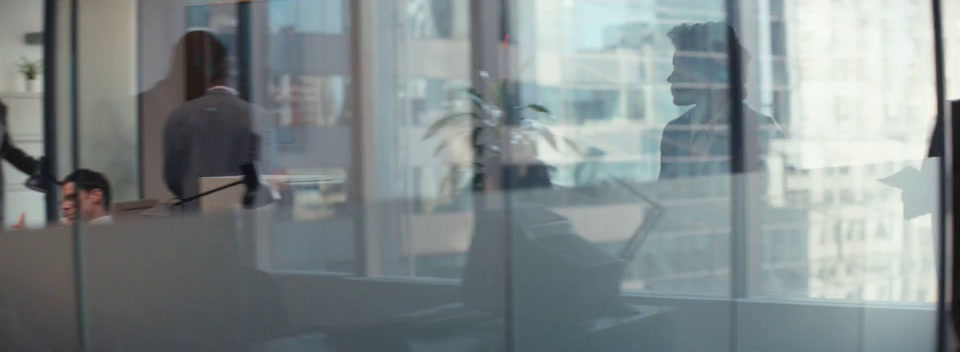 a group of people standing around a glass wall