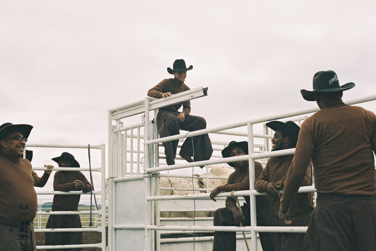 a group of men standing on top of a white fence