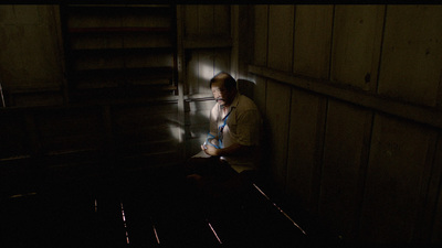 a man sitting on a bench in a dark room