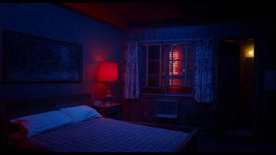 a bed in a dark room with a red light on