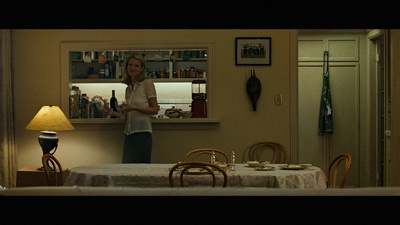 a woman standing in a kitchen next to a table