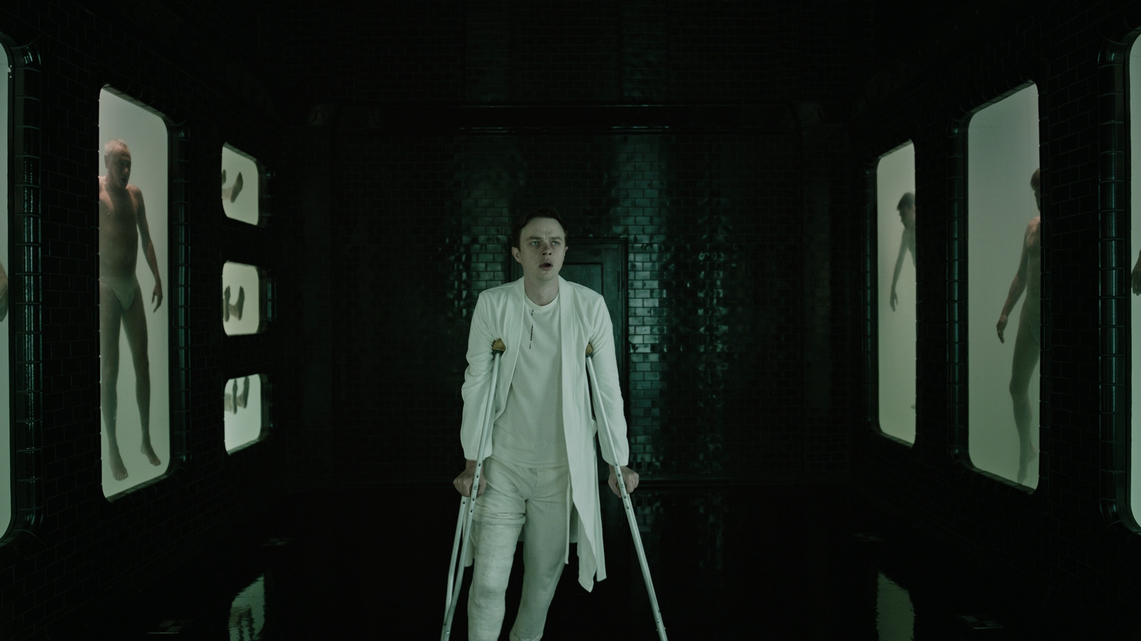 a man with crutches standing in a dark room