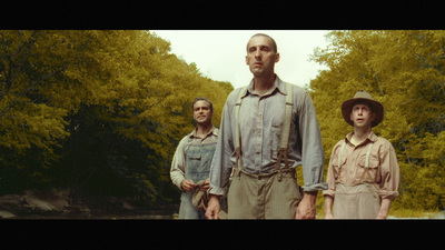 a man standing next to two other men