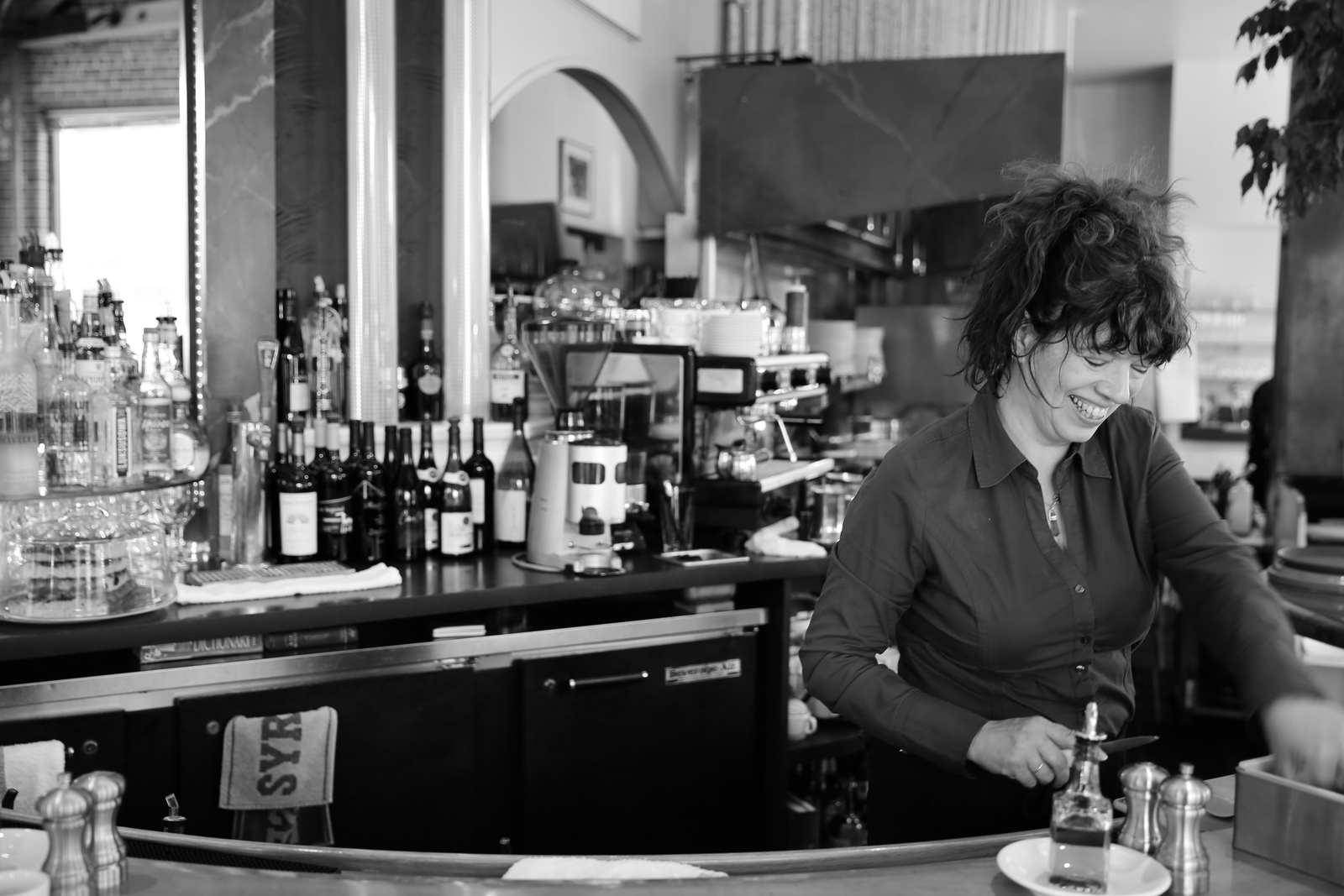 a woman standing at a bar making a drink